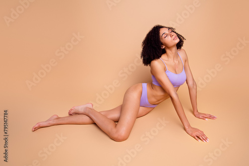 Full body no filter portrait of stunning model girl closed eyes sit floor isolated on beige color background