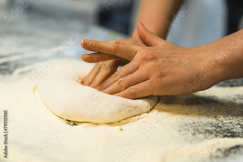 hands steading the dough in the flour, working in the kitchen. High quality photo photo