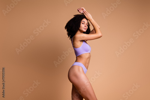 No retouch photo of charming woman showing athletic forms shape butt stretch marks empty space isolated on beige color background