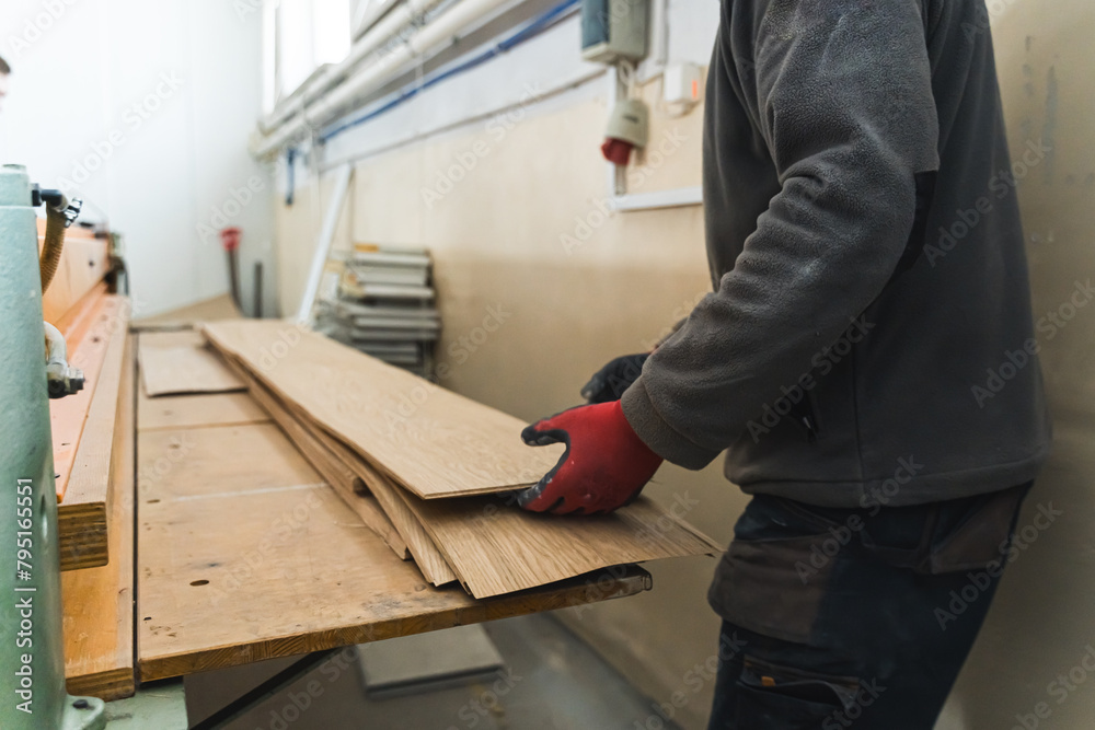 Carpenter moving large scale wooden planks at the workshop. High quality photo Carpenter moving large scale wooden planks at the workshop. High quality photo