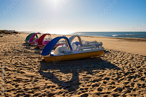 Beautiful summer landscape of the Spanish coast, two sun loungers, sun loungers and parasol. Fine golden sand, sea view with horizon,blue sky, calm and relaxation. Inspiring vacation landscape. photo