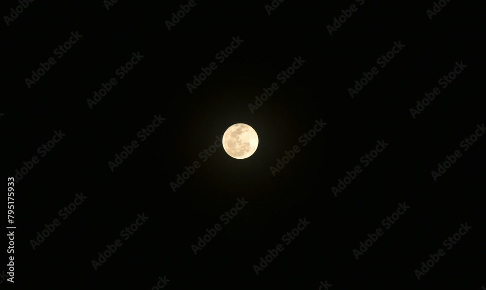 bright yellow full moon floating on sky in night background