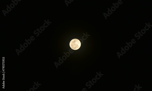 bright yellow full moon floating on sky in night background