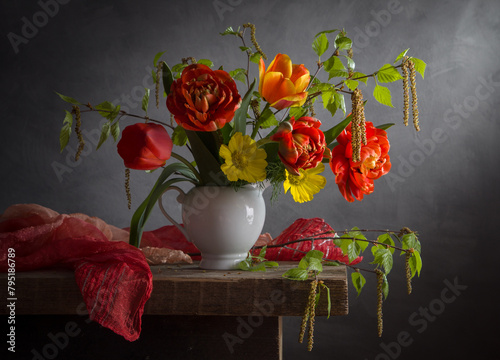 Still life with a bouquet of tulips and birch branches on a wooden table