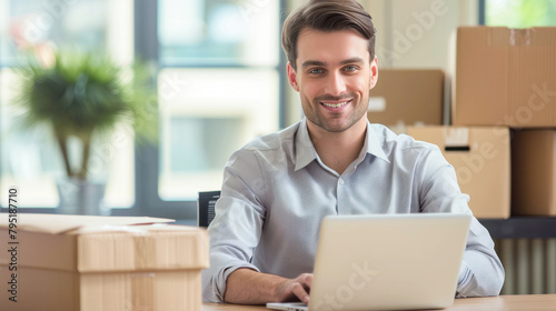 Issuing orders from the warehouse. Young smiling man groups the order. man with a laptop and boxes on the background of the warehouse. Order picker. Delivery, shipping department