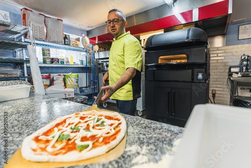 pizza is ready for baking, Putting pizza in oven at restaurant kitchen. High quality photo photo