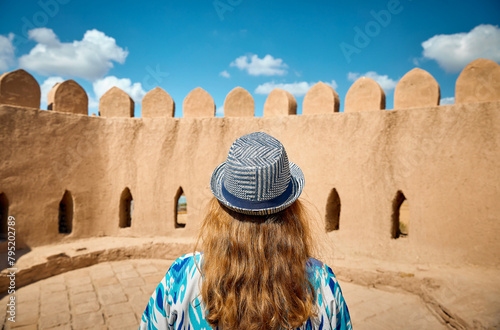Tourist in ethnic dress at city walls Ichan Kala of Khiva photo