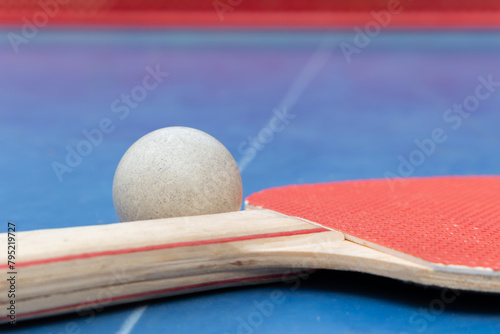 angle view pingpong racket and ball and net on a blue pingpong table at horizontal composition © Freer