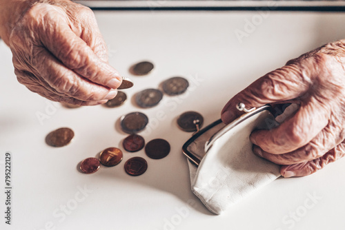 Detailed closeup photo of elderly 96 years old womans hands counting remaining coins from pension in her wallet after paying bills. Unsustainability of social transfers and pension system.