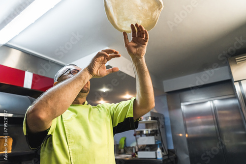 selective focus on the dough that the chef throws up the air. Process of making a pizza base. High quality photo photo