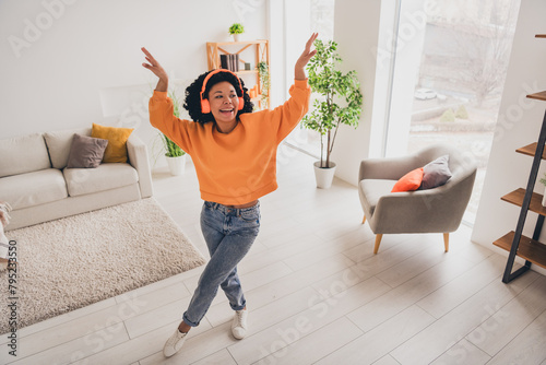Photo portrait of lovely young lady dance headphones weekend dressed casual orange clothes cozy day light home interior living room © deagreez