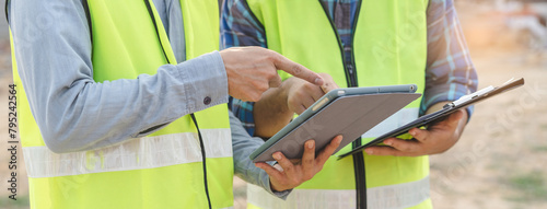 Builder engineer and supervisor consultant inspection job plan  concept, Asian contractor and foreman looking blueprint in computer laptop and checking process plan of factory warehouse construction