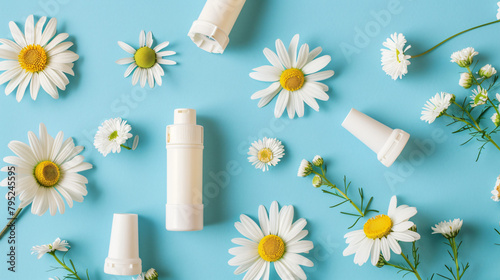 Asthma inhalers with daisy flowers on blue background photo