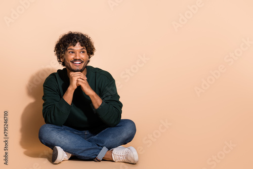 Full body portrait of nice young man look empty space wear sweater isolated on beige color background © deagreez