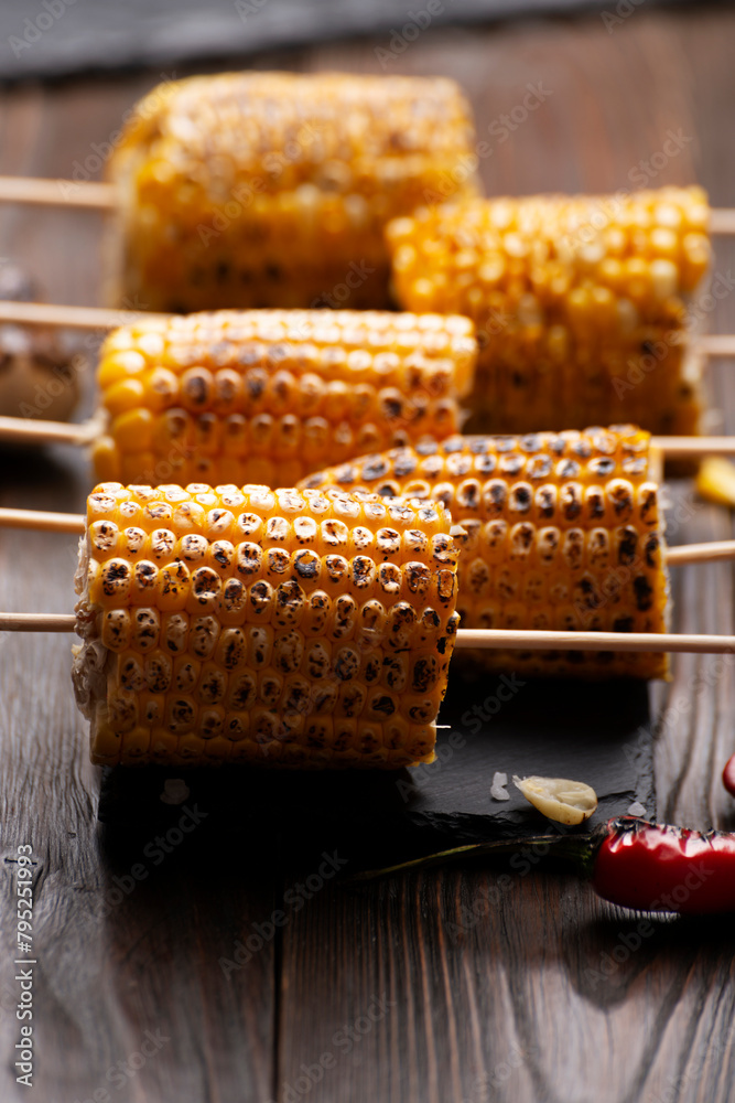 Slate tray with Pieces of Grilled corn on the cob on kitchen table healthy food background