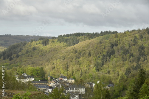 Région de collines et vallée encaissée boisée sous le contraste entre éclaircies et ombres à Bouillon  photo