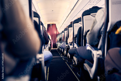 The cabin of a commercial aircraft with rows of seats along the aisle. Morning light in the cabin of the airline. Economy class. High quality photo