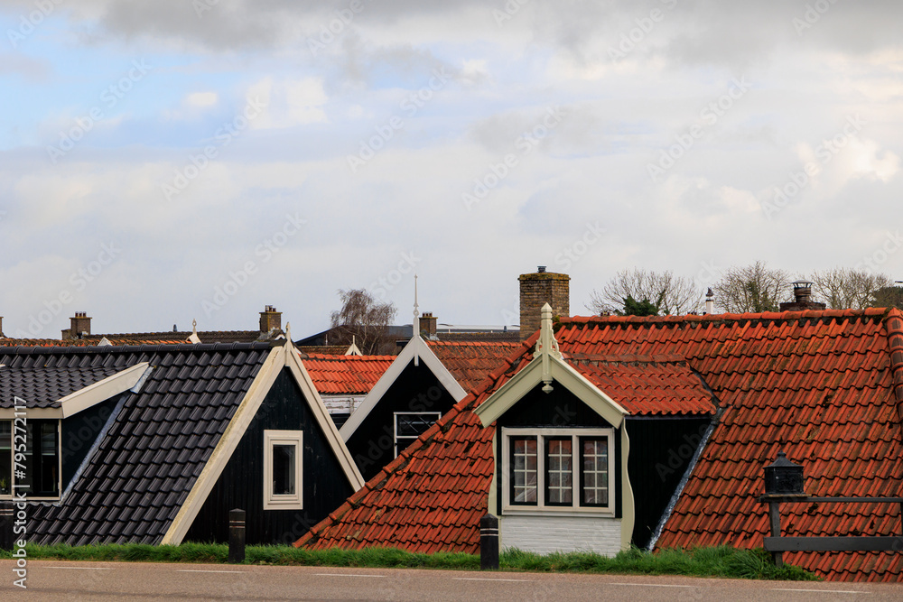 The roofs of houses in the Dutch village of Dalmeer tower over the dam on the North Holland Canal