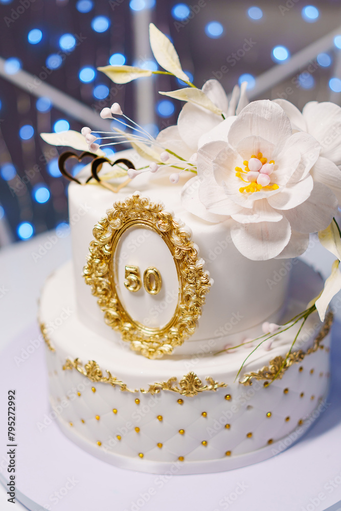 Beautiful white two-tiered cake decorated with flowers. 50th Anniversary Cake.