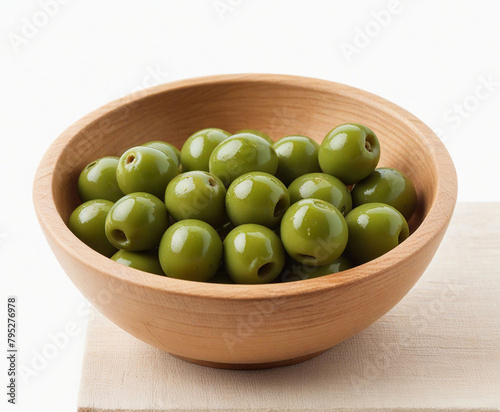 Green olives in wood bowl , cut out on white background