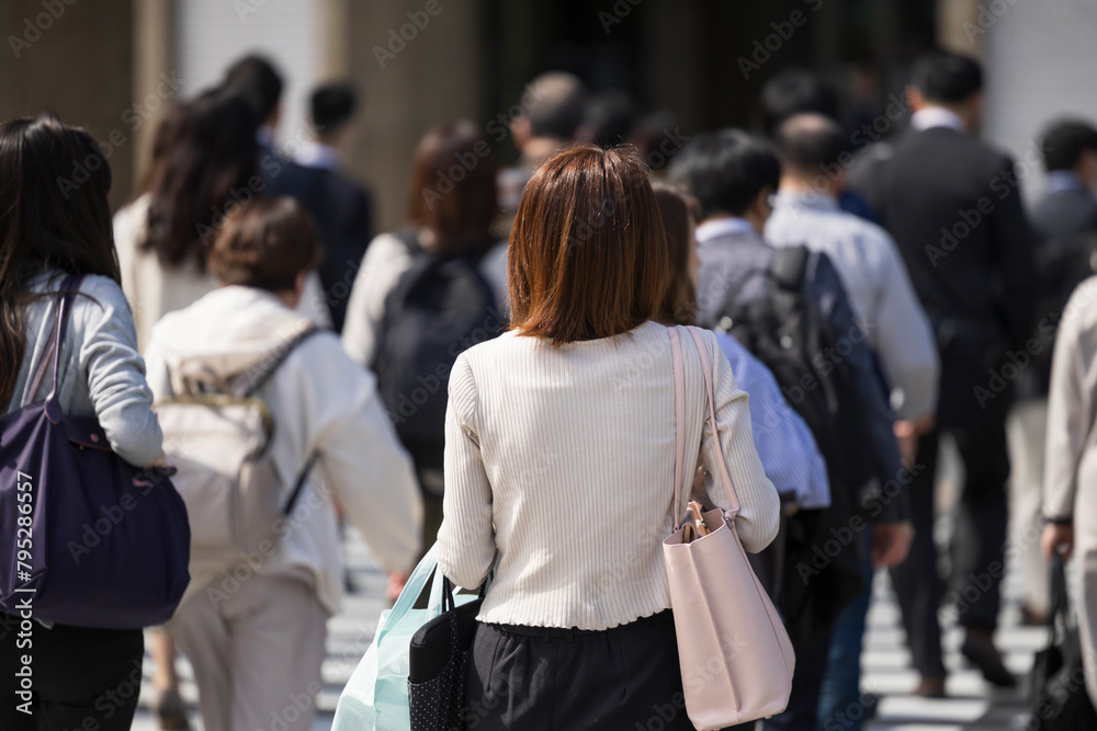 ビジネス街の横断歩道を渡る日本人女性の後ろ姿