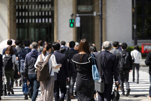 ビジネス街の横断歩道を渡る日本人女性の後ろ姿 photo