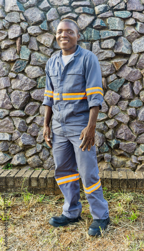 young african worker in workwear , stone wall in the background © poco_bw