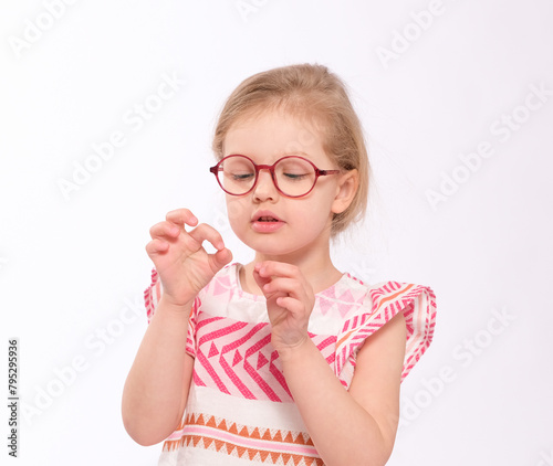 Adorable little girl holds something very small or shows something small;