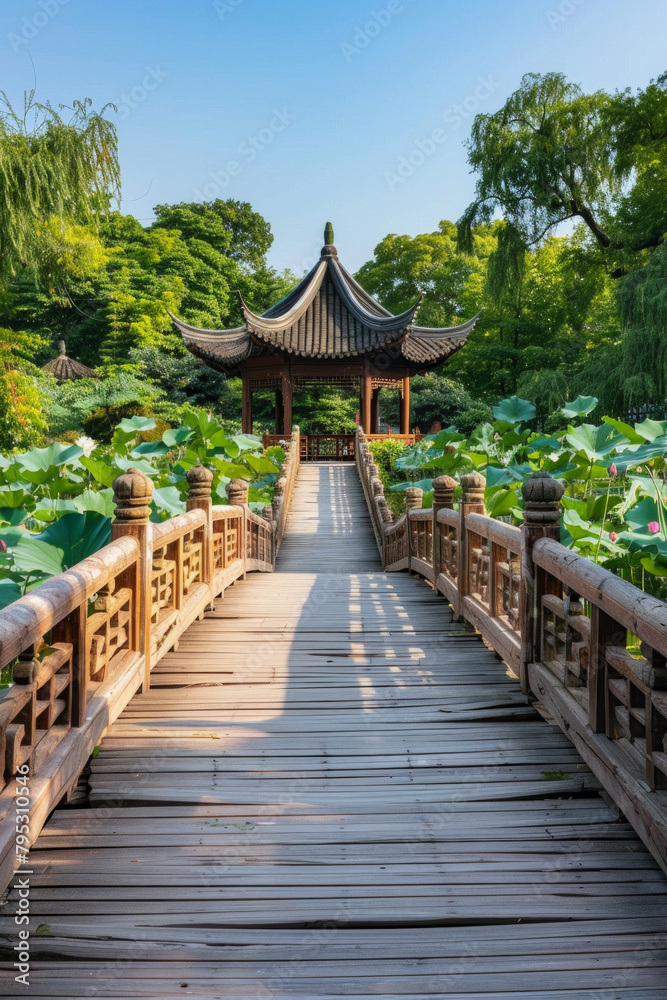 A wooden bridge in a lotus pond, with a Chinese pavilion in the background A wooden bridge in a lotus pond, with a Chinese pavilion in the background