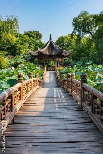 A wooden bridge in a lotus pond, with a Chinese pavilion in the background 