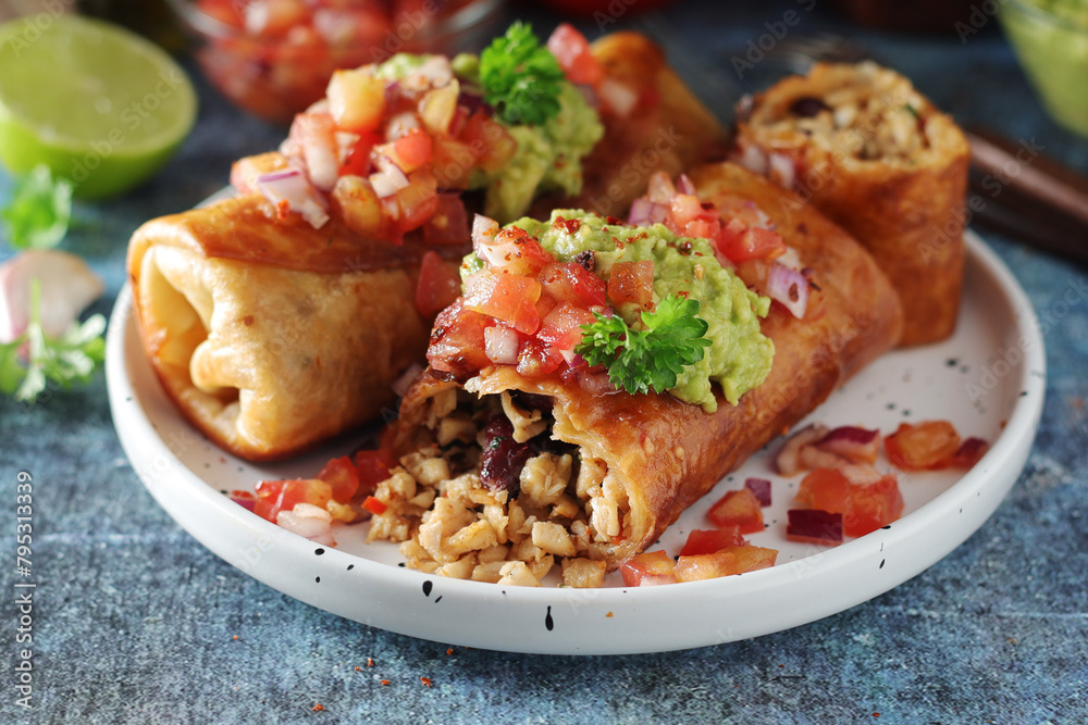 A typical dish of Mexican cuisine - Chimichanga, made of tortilla with different ingredients A typical dish of Mexican cuisine - Chimichanga, made of tortilla with different ingredients
