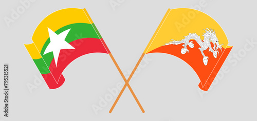 Crossed and waving flags of Myanmar and Bhutan