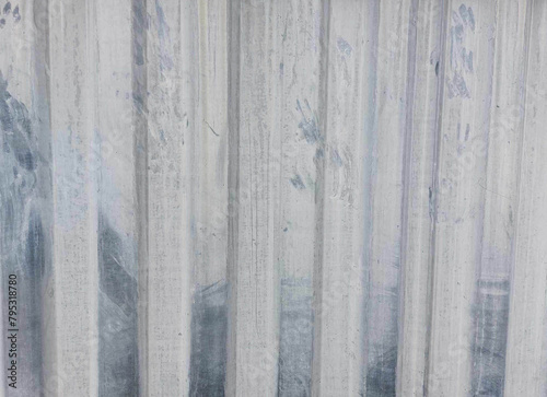 The surface texture of a dirty white painted metal fence