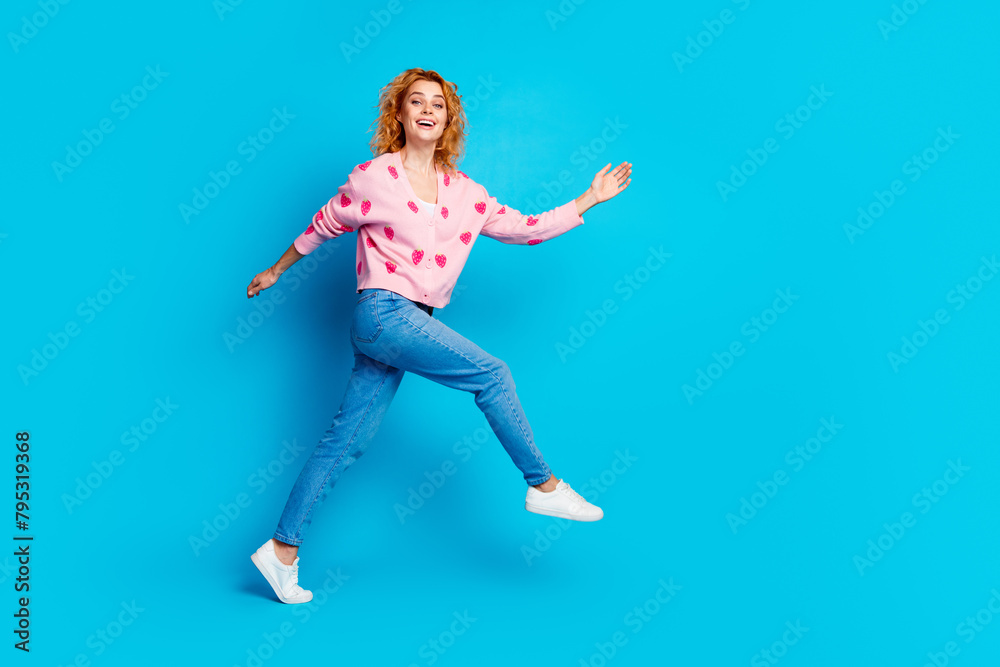 Full length photo of lovely young lady running have fun dressed stylish pink clothes isolated on blue color background