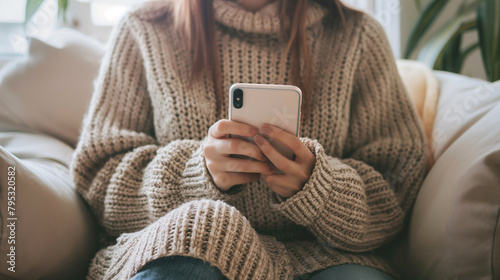 Mulher vestindo uma blusa de lã usando um celular  photo