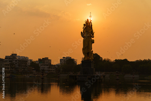 The Statue of Hindu god Lord Shiva in Sursagar Lake is seen at sunset in Vadodara city in the state of Gujarat. Concept of hinduism religion