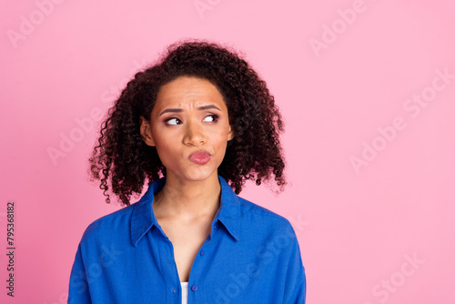 Photo of minded cute woman wear blue trendy clothes look empty space hmm offer look empty space isolated on pink color background