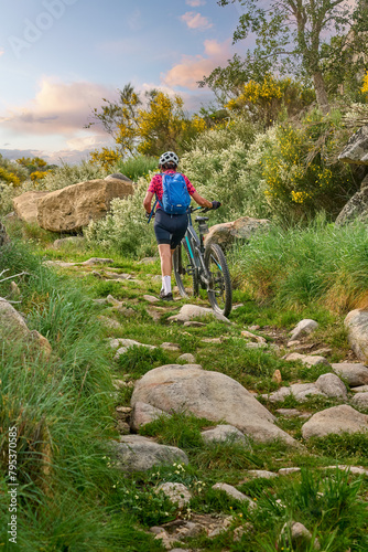 active senior woman cycling with her electric mountain bike in the rough landscape of National Parc Serra de São Mamede near Marvao in central Portugal, Europe