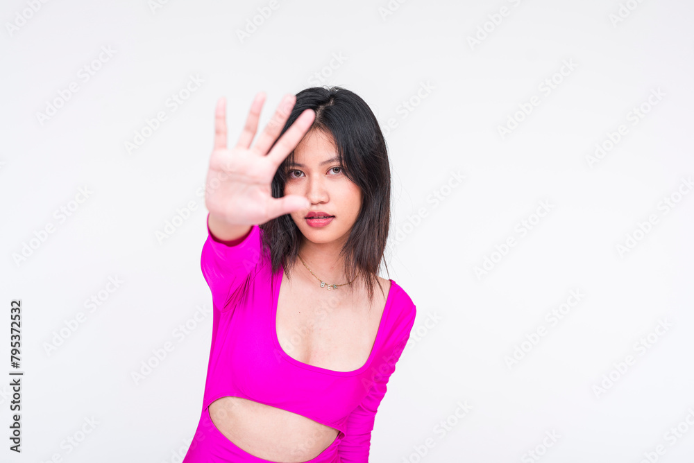 Young woman in magenta dress saying no with hand gesture, isolated on white Young woman in magenta dress saying no with hand gesture, isolated on white