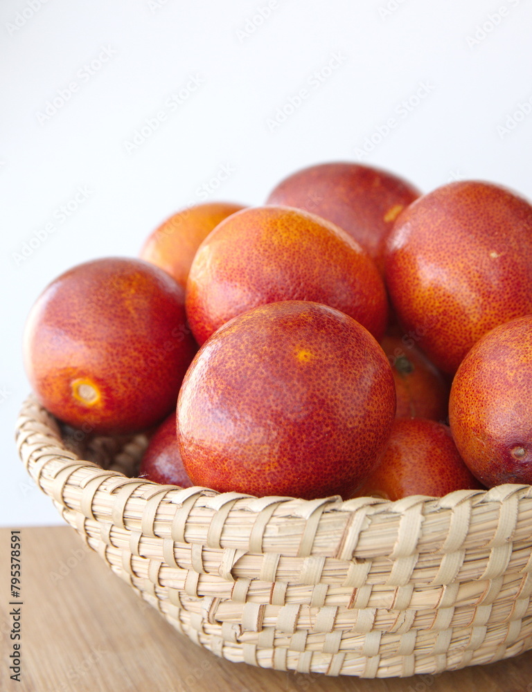 Italian Blood oranges on woven basket, Citrus sinensis Sweet red Orange, sliced fruit on white background Italian Blood oranges on woven basket, Citrus sinensis Sweet red Orange, sliced fruit on white background