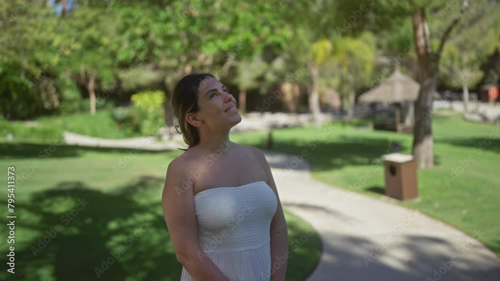 Smiling young woman in a white dress standing at a sunny bali resort garden Smiling young woman in a white dress standing at a sunny bali resort garden