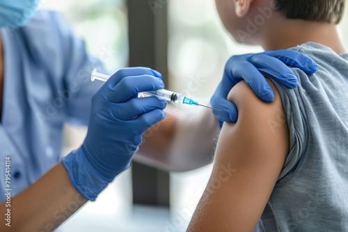 Child receiving a vaccination. Little boy in face mask in doctor's office is vaccinated. Kid giving injection shot. Syringe with covid-19, coronavirus, flu vaccine. Dangerous infectious disease, MPOX photo