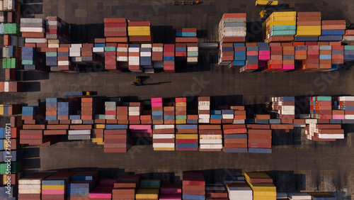 Aerial top view over international containers cargo ship at industrial import-export port prepare to load containers with big container loader ship vessel. global transportation and logistic business