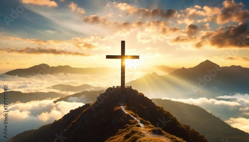 holy cross on top of mountain at sunset or sunrise symbolizing the death and resurrection of jesus christ hill is shrouded in light and clouds horizontal background religion christianism concept