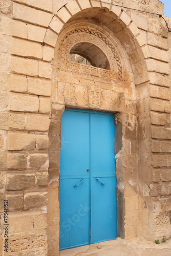 Bright blue door in an elaborate facade of a traditional house in the old town of Mardin, Turkey © anja