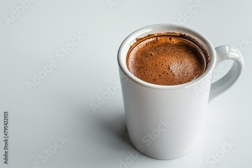 A white coffee cup with a brown liquid in it