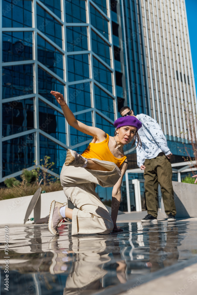 Vertical Screen: Young And Stylish Female Hip-Hop Dancer Freestyling On Street In the Circle Of Fashionable Friends. Group Of Young People Supporting Energetic Performer While She Is Practicing