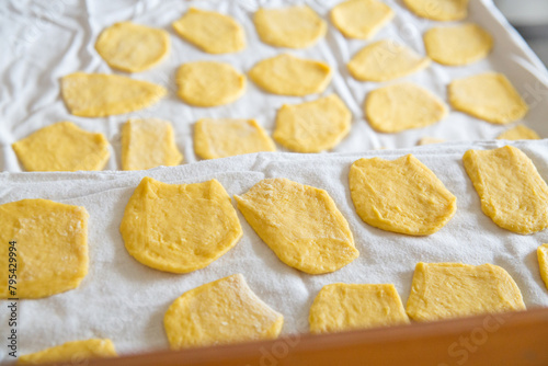 Top view above overhead of pieces of homemade noodle dough in kitchen with natural backlight, home atmosphere.