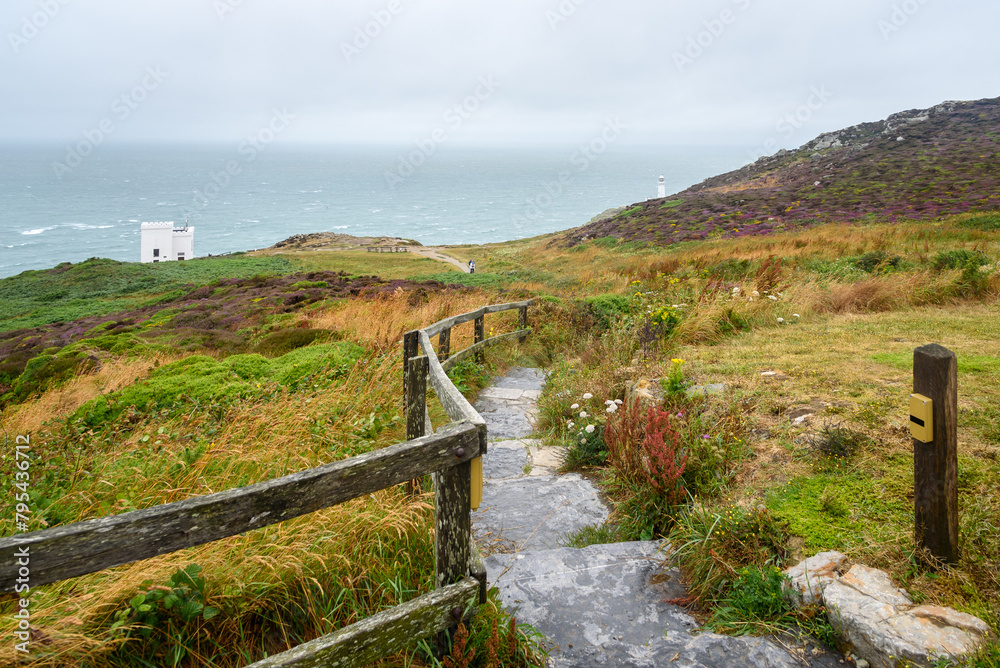 Narrow fenced path with steps leading to a clifftop viewpoint on a lighthouse along the coast of north Wales on a foggy summer day Narrow fenced path with steps leading to a clifftop viewpoint on a lighthouse along the coast of north Wales on a foggy summer day