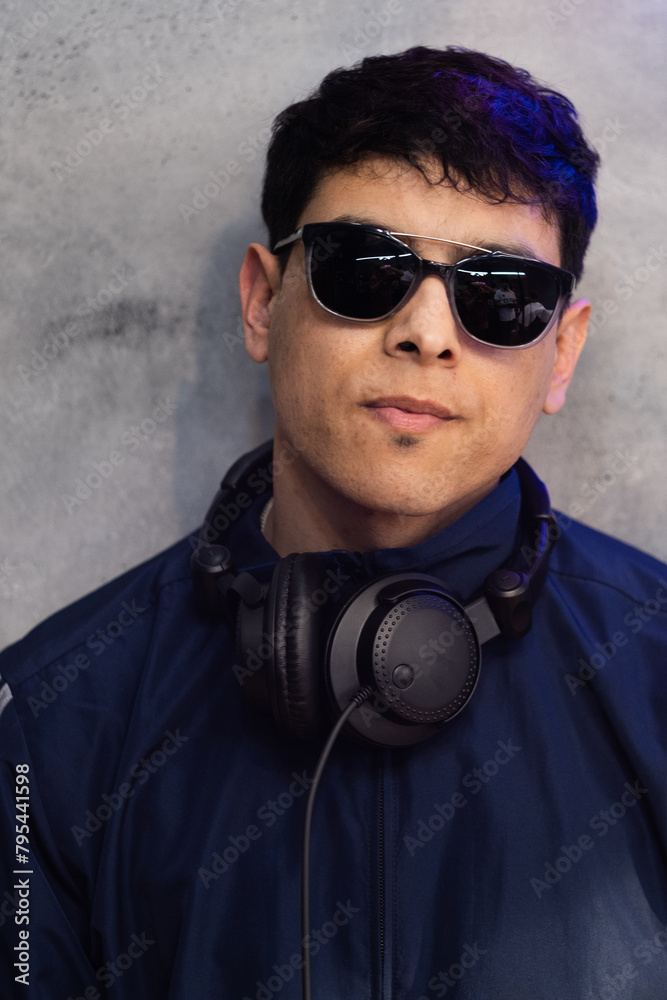 Obraz premium Dj posa con auriculares y gafas de sol